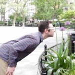 Person wearing Google Glass bending over to take pictures of flowers