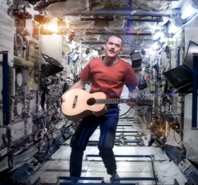 Chris Hadfield floating with his guitar in the ISS