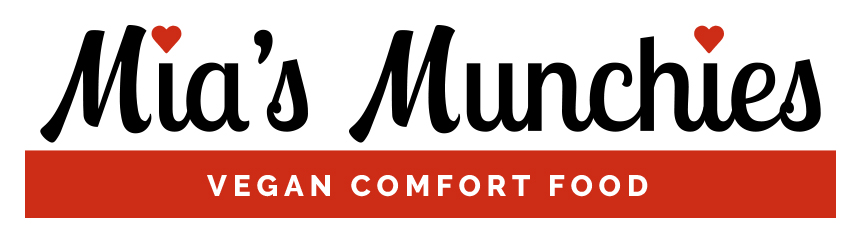 Mia's Munchies logo for use on white backgrounds: "Mia's Munchies" in black script type with red hearts for dots on the "i"s; red bar underneath type with "VEGAN COMFORT FOOD" in white sans serif all caps type, centered in bar. I created two other color versions for use on red and black backgrounds.