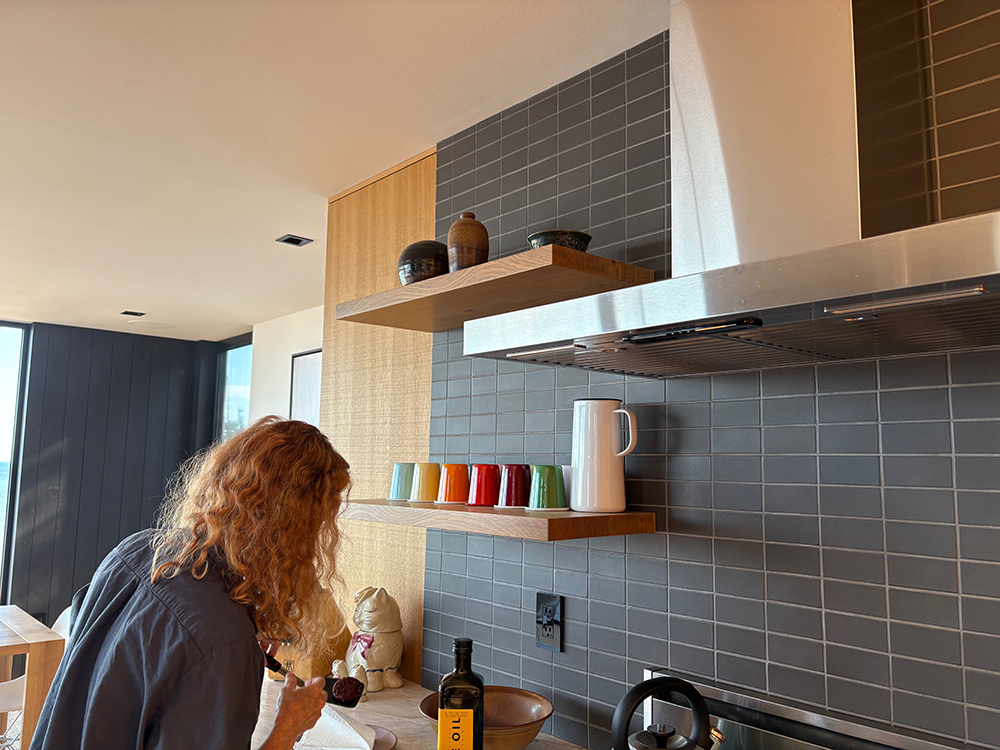 Red-headed woman leaning over the stove in a beautiful modern kitchen