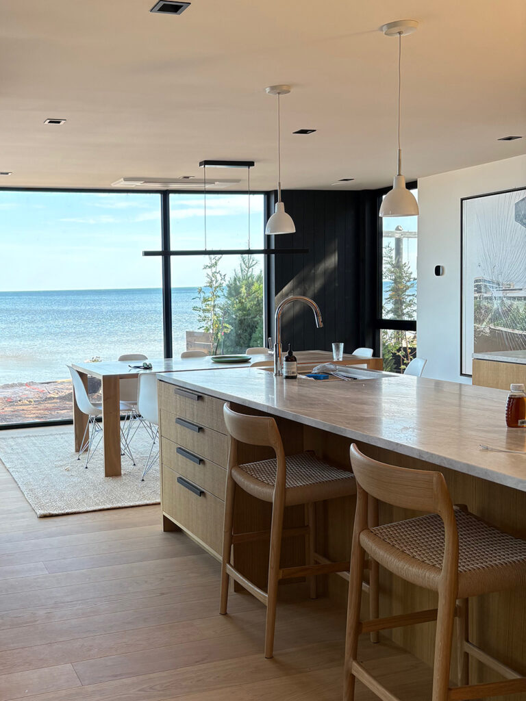 Open plan modern kitchen looking out onto blue lake