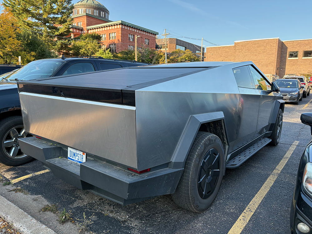 Side and back of Tesla Cybertruck with "DUMPSTER" license plate