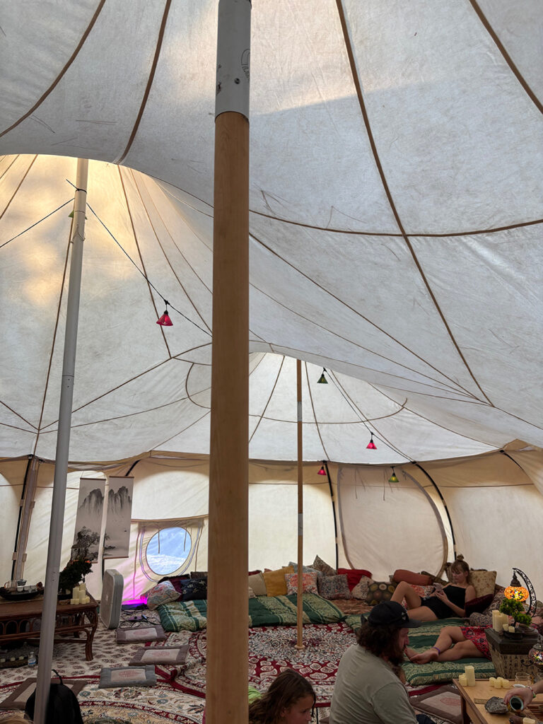 Interior of a large cream-colored canvas tent with wooden supports