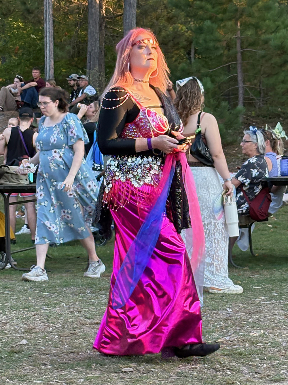 Woman with orange hair in long bright pink and purple dress