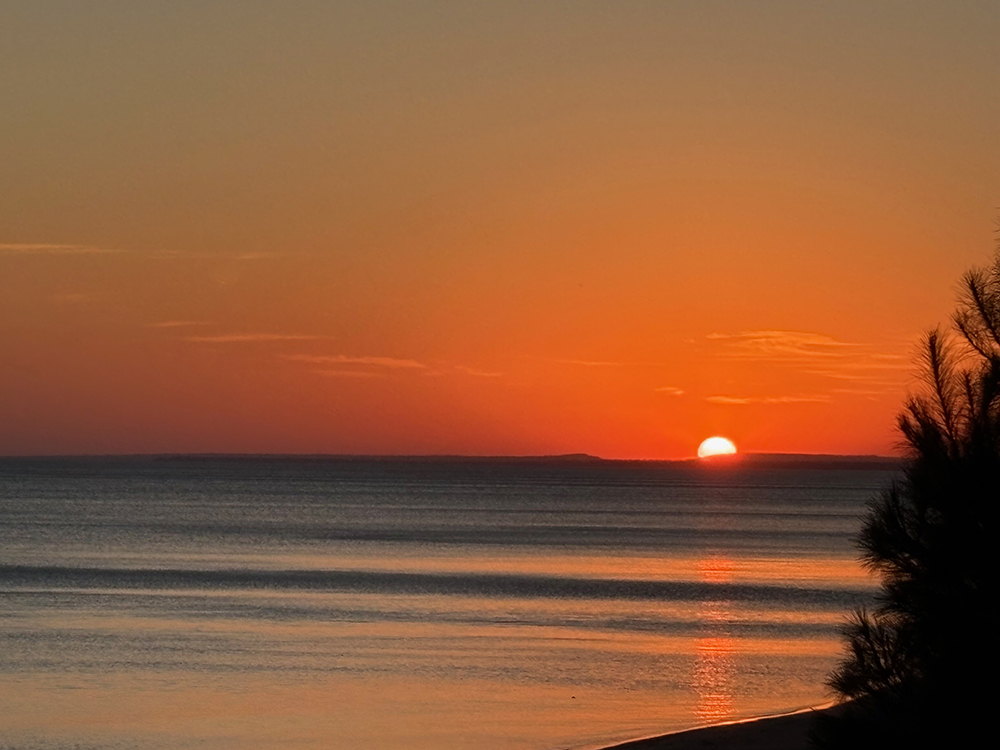 Colorful sunrise over lake - half of sun is visible