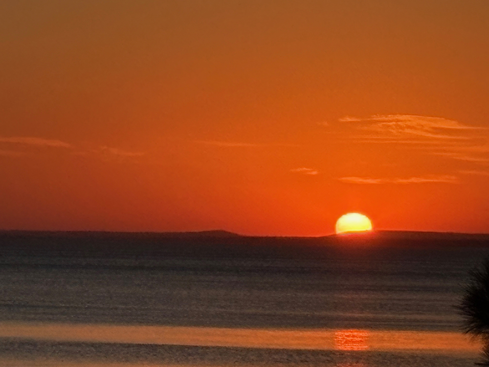 Colorful sunrise over lake - half of sun is visible - zoomed in
